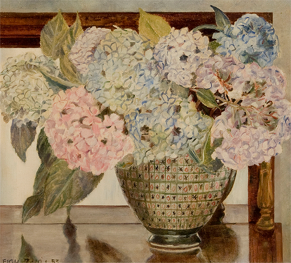 A bouquet of pink, white, and blue hydrangeas in a patterned vase on a polished surface. The bouquet's reflection is partially seen in the mirror with a rectangular frame behind them.