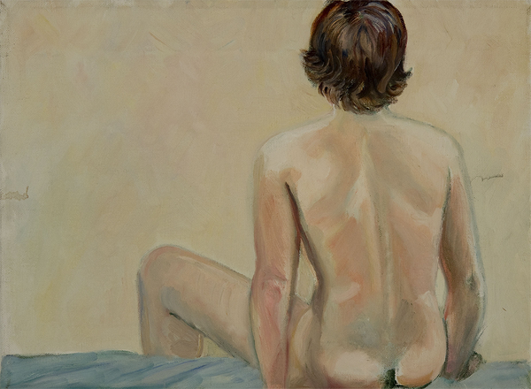 A model, Nancy, sits on a soft blue surface with their back turned to the viewer.