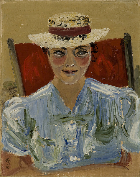 A woman in a yellow hat and blue top sits on a red chair, against a beige backdrop.