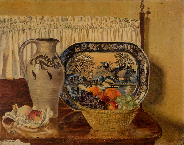 A vase, blue print tray, and basket of fruit sit on a brown table with a short white curtain.
